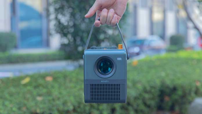 someone holding a portable projector with built-in speakers